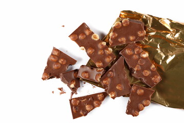 Chocolate bars with hazelnut, pieces with golden aluminum foil isolated on white background, top view