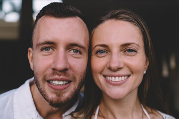 Close up portrait of cheerful male and female smiling at camera during love photo session for together time spending, happy Caucasial husband and wife posing during date with good vibes for recreation