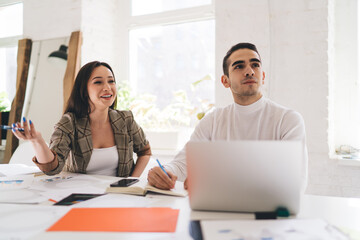 Cheerful colleagues working on project in office