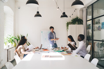 Group of diverse coworkers discussing project in office
