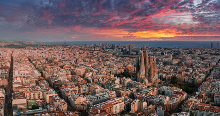 Aerial view of Barcelona City Skyline and Sagrada Familia Cathedral at sunset. Eixample residential...