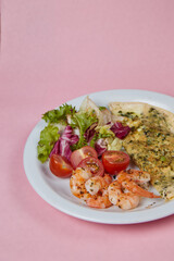 breakfast plate scrambled eggs with shrimps and tomatoes, on monochromatic delicate background, side view