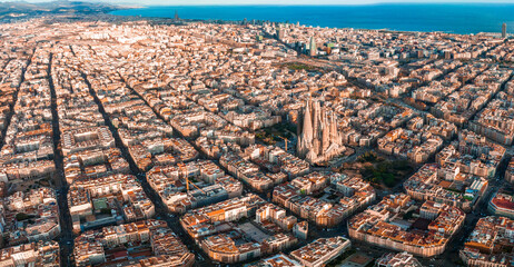 Aerial view of Barcelona City Skyline and Sagrada Familia Cathedral at sunset. Eixample residential...