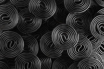 Stacks of circularly rolled black liquorice. Illustration of the concept of herbalism and medical use of liquorice and as a design background for web and presentation