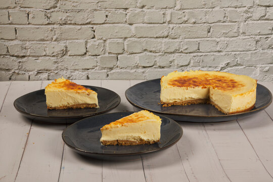 cheesecake and slices on a white brick wall