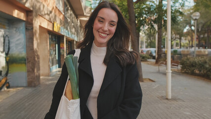 Close-up of young woman smiling while standing outdoors and looking at camera