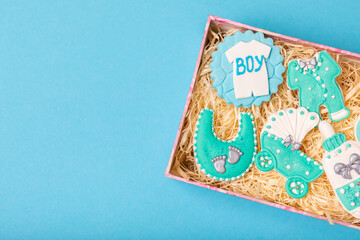 A set of baby shower cookies in a gift box on a colored background. Holiday concept. Baby party. View from above. Flat lay.