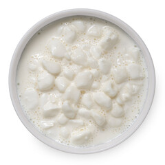 Chunky cottage cheese in cream in white ceramic bowl isolated on white. Top view.