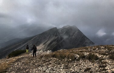 Zwei Bergwanderer zwischen Wolken und Nebelschwaden beim Abstieg vom Sonntagshorn, Heutal, Unken, Alpen, Tirol, Österreich