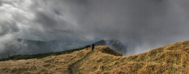 Bergwanderer (männlich) zwischen Wolken und Nebelschwaden zwischen Peitingköpfl und Sonnstaghorn, Heutal, Unken, Alpen, Tirol, Österreich