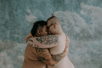 non-binary queer couple embracing heads together