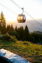 Cabina de teleférico en el aire, en el bosque en puesta de sol