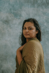 Portrait of an East Indian woman looking at camera with hand on chest