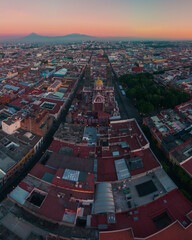 Amanecer en la catedral de Puebla con perspectiva hacia los volcanes, con dron