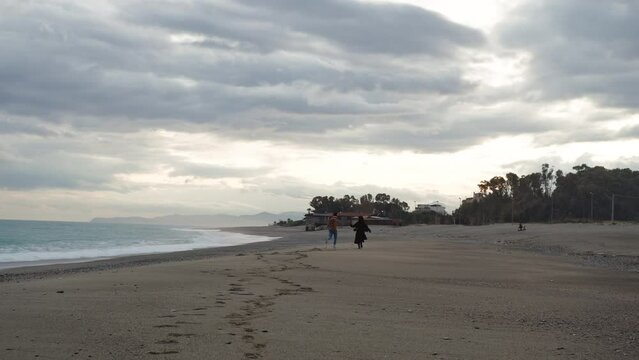 Happy Valentines Couple walks On The Beach in cloudy day