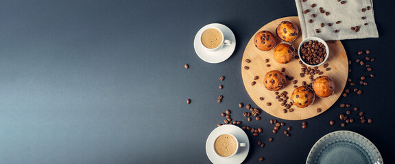 Desayuno con taza de café, muffins de chocolate, en madera, con granos de café, en fondo banner largo oscuro azul