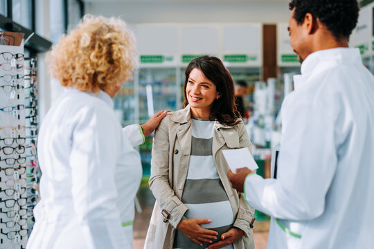 Pharmacists advising pregnant woman.