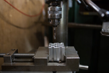 Cutting a screw with a tapping machine - obrazy, fototapety, plakaty