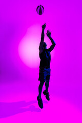 Fototapeta na wymiar Basketball player throws the ball on studio background. Advertising concept