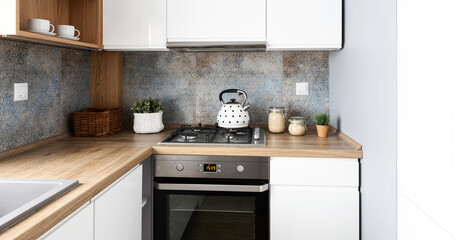 Small kitchen with white cabinets, modern furniture and tiles pattern on the wall. Wooden counter...