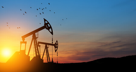 Fototapeta premium The change in oil prices caused by the war. Oil prices are rising because of the global crisis. Oil drilling derricks at desert oilfield. Crude oil production from the ground. Petroleum production.