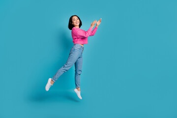 Fototapeta na wymiar Full length photo of funky adorable woman dressed pink sweater jumping high empty space isolated blue color background