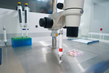 Microscope and stripper on table for preparatory work with biomaterial