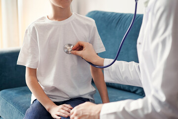 Unknown doctor and kid boy patient at usual medical inspection. Medicine, healthcare concepts