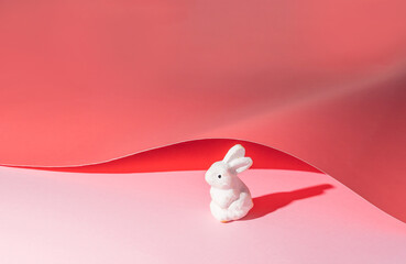 Easter bunny under a pink paper cover. Minimal Easter holiday concept
