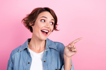 Portrait photo of young positive surprised girl wearing denim shirt shirt looking interested new product promotion isolated on pink color background