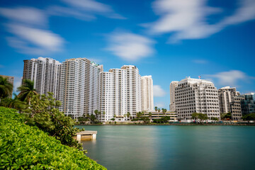 Fototapeta premium Long exposure photography. Brickell Miami buildings waterfront scene. Motion blur water and clouds