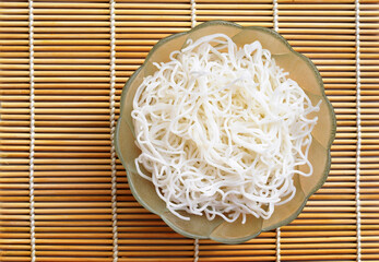 Cooked rice noodles in a bowl, top view