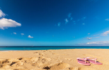 Fototapeta na wymiar Flip flops on the beach of Jandia, Las Palmas. Sunny day and long exposure shot.