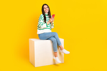Fototapeta premium Full length photo of positive lovely lady wear stylish clothes look empty space interesting offer isolated on yellow color background