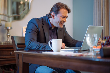 Hombre de negocios viendo con satisfacción información en su computadora personal.