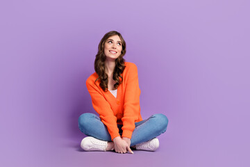 Full length photo of cute dreamy lady wear orange cardigan looking empty space sitting floor...