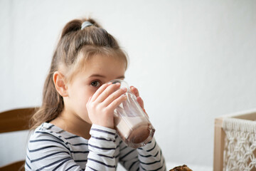 little girl drinking cocoa. free space