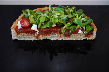 Cake slice of vegetables lying on the black mirror surface. Healthy cooking concept