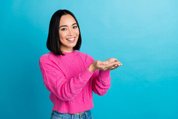 Photo of positive lovely thai person arms palms hold demonstrate empty space isolated on blue color...