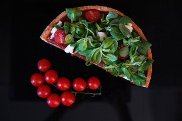 Cake slice of vegetables lying on the black mirror surface. Healthy cooking concept
