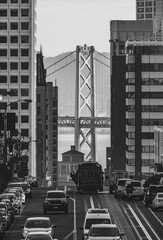 Bay bridge with and cable car on the street in San Francisco