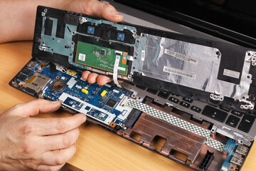 Fototapeta na wymiar Connection of wires inside disassembled laptop, repair
