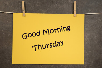 Napis Good morning Thursday na wiszącej żółtej kartce na ciemnym tle - obrazy, fototapety, plakaty