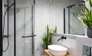Modern bathroom with shower, mirror on the wall and ceramic washbasin. Stylish interior with simple...