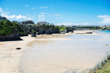Beautiful Newquay beach with blue sea, stone cliffs and white sand in Cornwall, south west England, selective focus