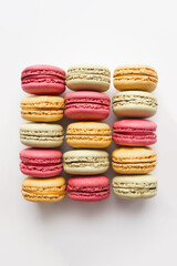 Set of multi-flavored macaroons cookies extremely close up. Vertical wallpaper or background for cafes and confectionery. Selective soft focus, copy space.