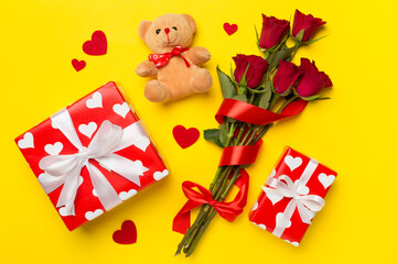 Valentines day gifts with red roses on color background, top view
