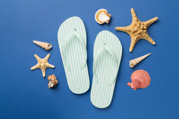 Striped flip flops on color background, top view
