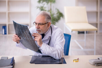 Old male doctor radiologist working in the clinic