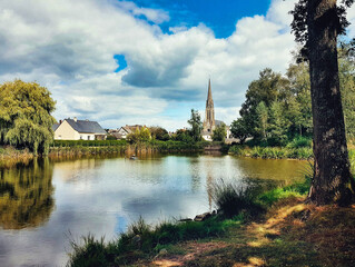 Obraz premium View of the pond and the church of Étrelles, France
